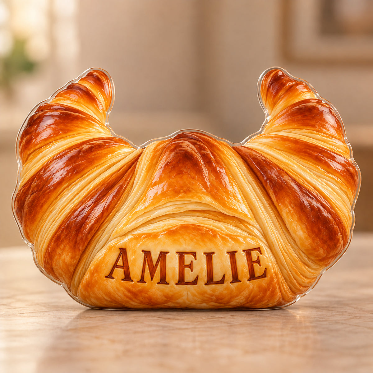 Digital preview of a amber croissant subject-shaped acrylic plaque with AMELIE printed on its lowest illustrated pastry fold