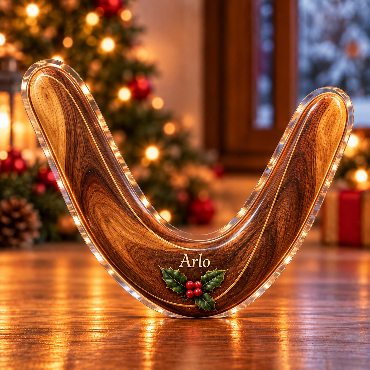 Front-view digital preview of a Christmas boomerang outdoor joy acrylic plaque with example name Arlo integrated into the the illustrated lower wood grain name detail