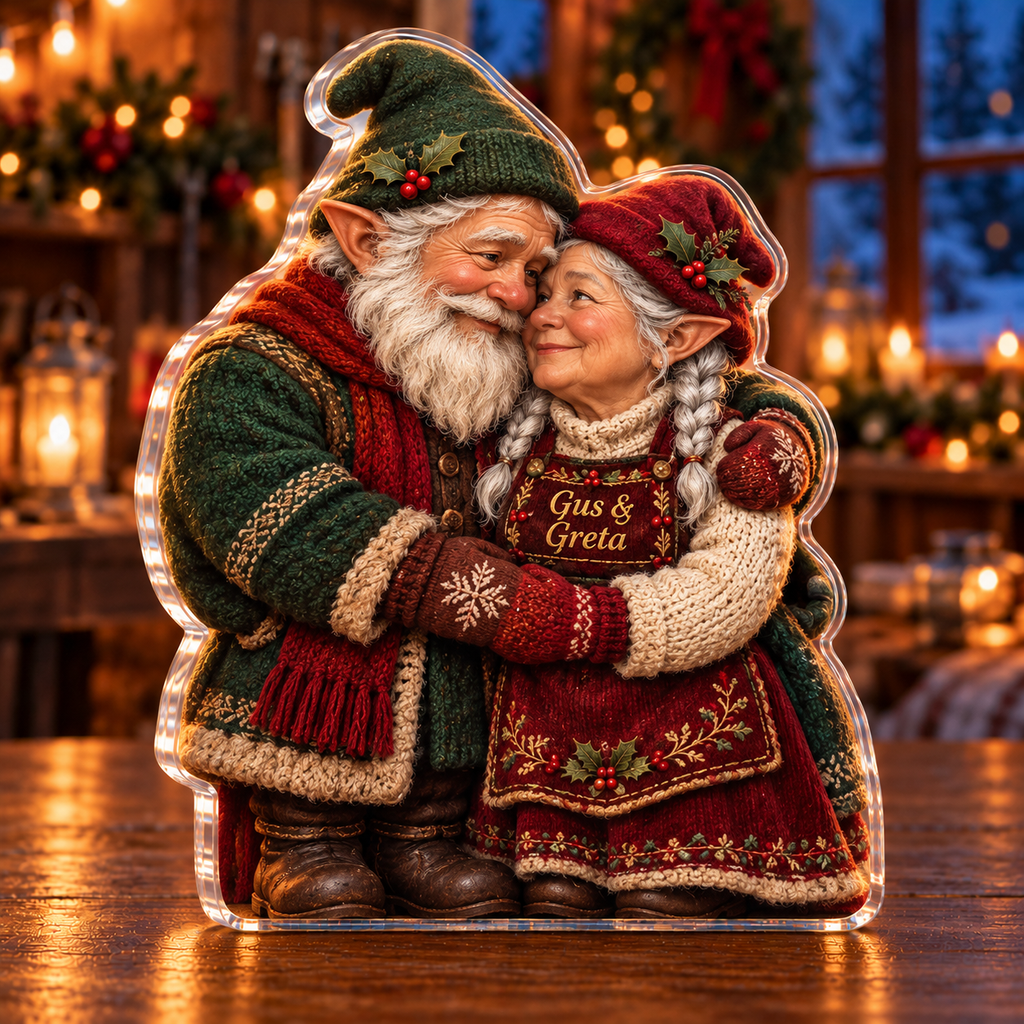 Front-view digital preview of a Christmas gnome couple embrace acrylic plaque with example name Gus & Greta integrated into the illustrated apron chest panel