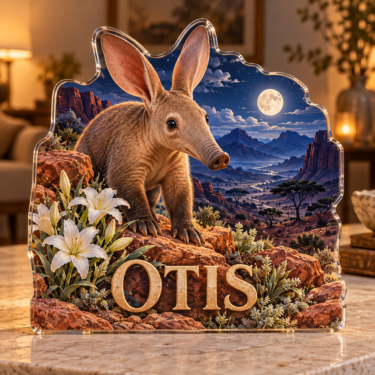 Front view of personalized aardvark desert lily moon valley acrylic plaque with sample name OTIS, displayed in a softly blurred warm naturalist sitting room at dusk on pale stone console