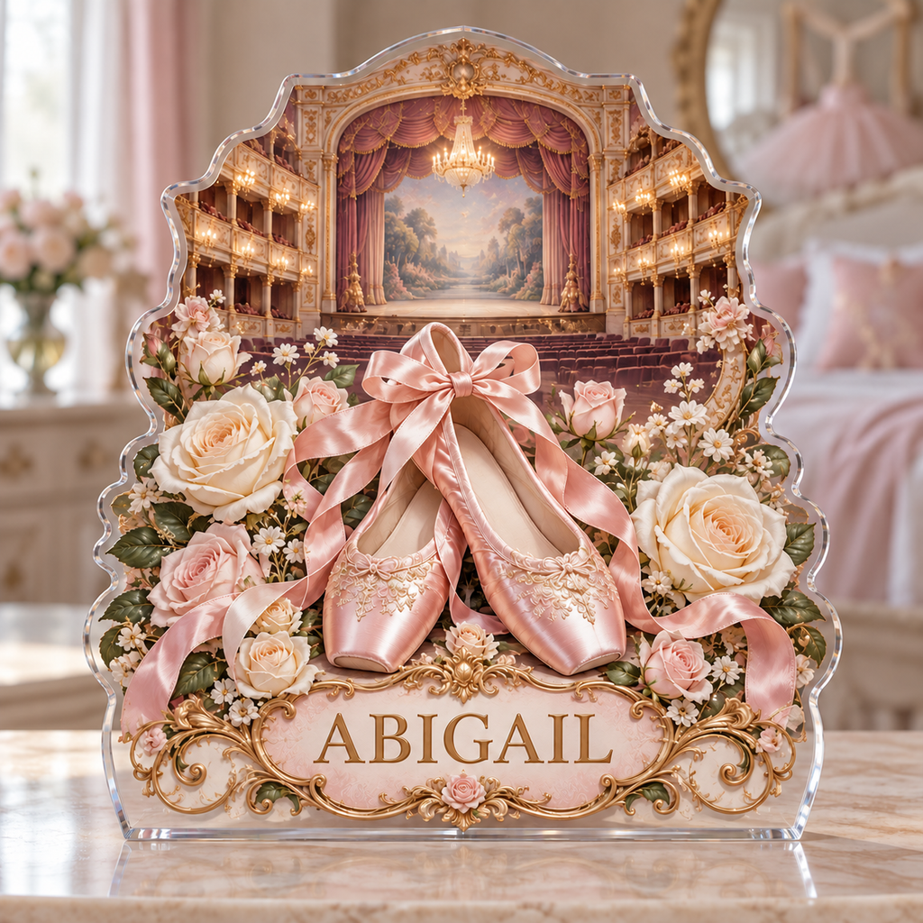Front view of a ballet slippers rose theater custom-shape acrylic plaque with example name ABIGAIL, displayed in a softly blurred elegant dance-inspired bedroom on pale stone console