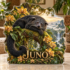 Front view of personalized binturong orchid canopy waterfall acrylic plaque with sample name JUNO, displayed in a softly blurred tropical naturalist sitting room on pale stone console